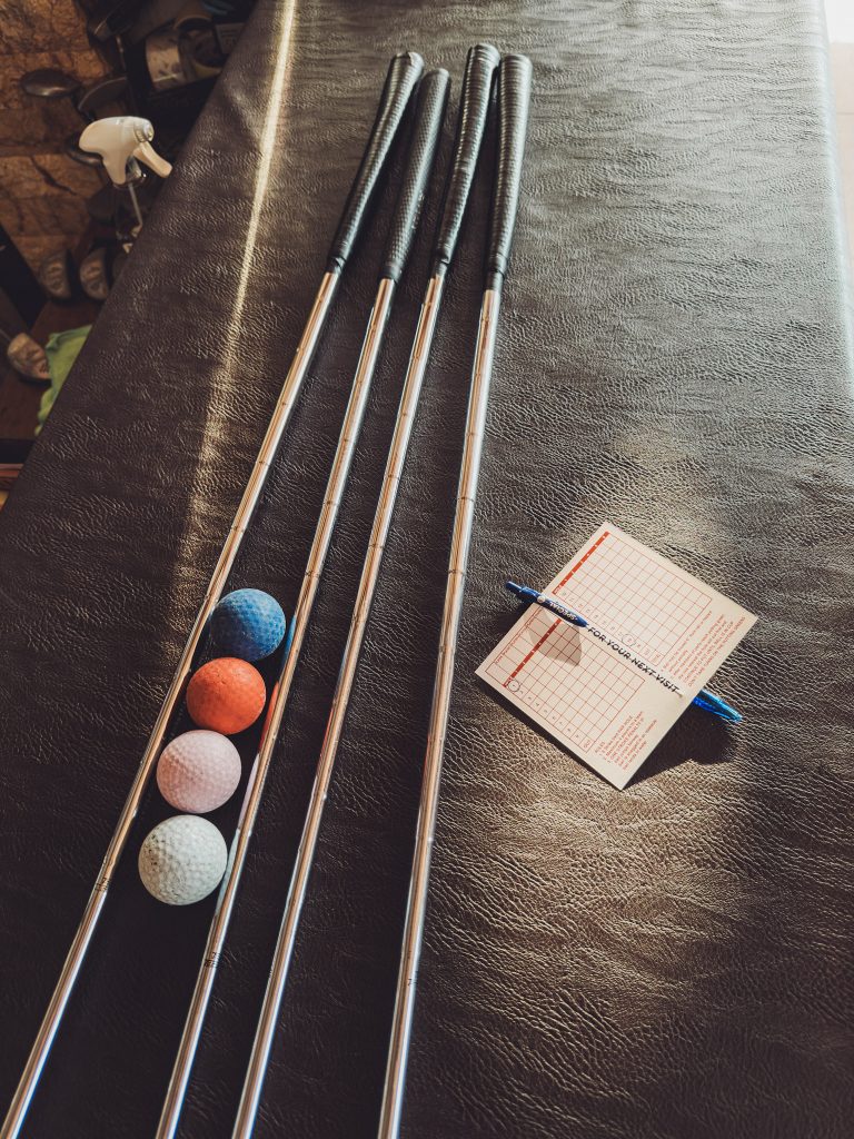 Minigolfschläger und bunte Golfbälle mit Scorecard im Minigolfpark Zakynthos, Griechenland