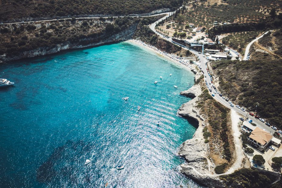 Blick aus der Luft auf die geschützte Bucht Makris Gialos auf Zakynthos mit klarem Wasser, Booten und der umliegenden Berglandschaft