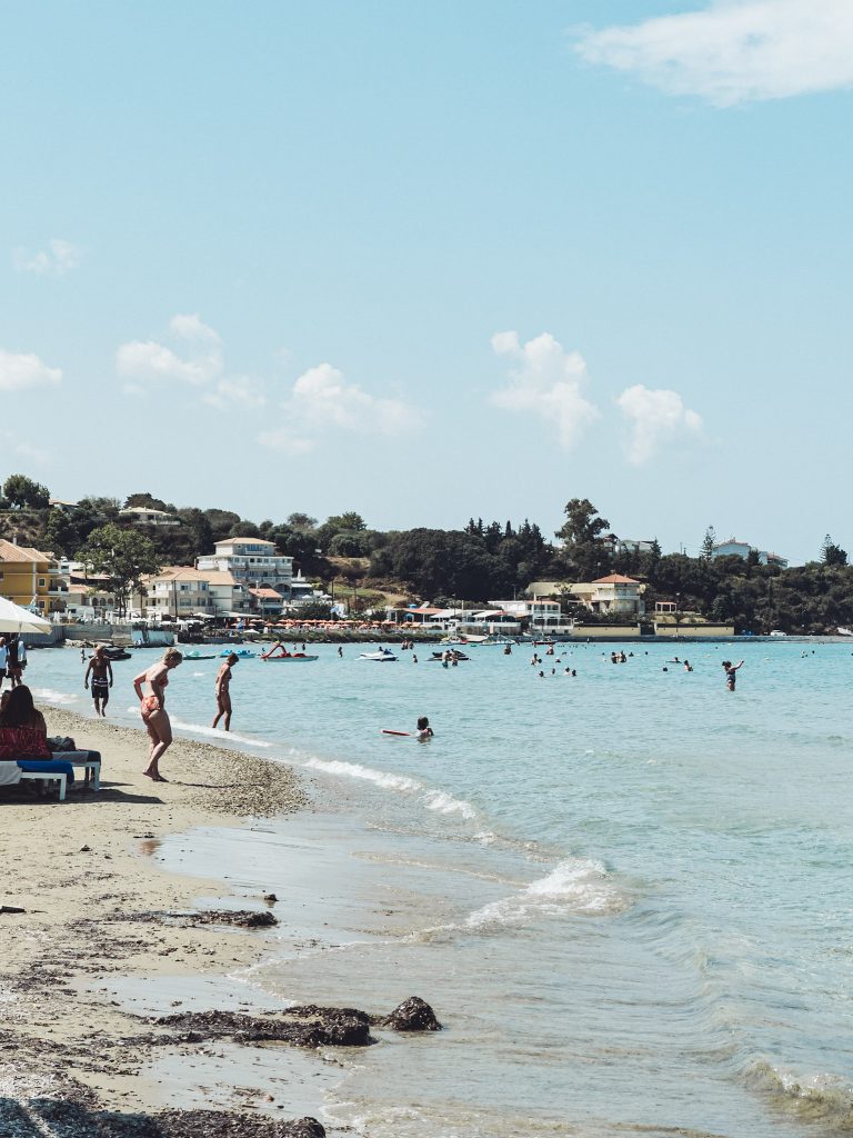 Belebter Strand mit Badenden und Wasserspielzeug auf Zakynthos