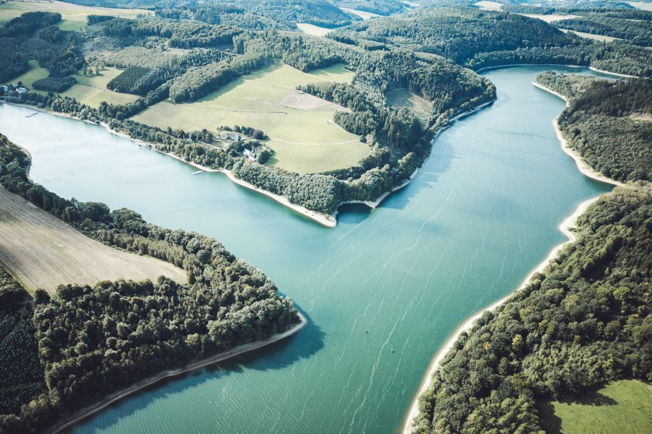 Diese Luftaufnahme zeigt, wie sich der Hennesee durchs Sauerland schlängelt – ein Ort voller Ruhe, Weite und echter landschaftlicher Vielfalt.
