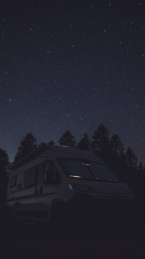 Camper unter einem klaren Sternenhimmel auf einem Stellplatz im Schwarzwald bei Nacht