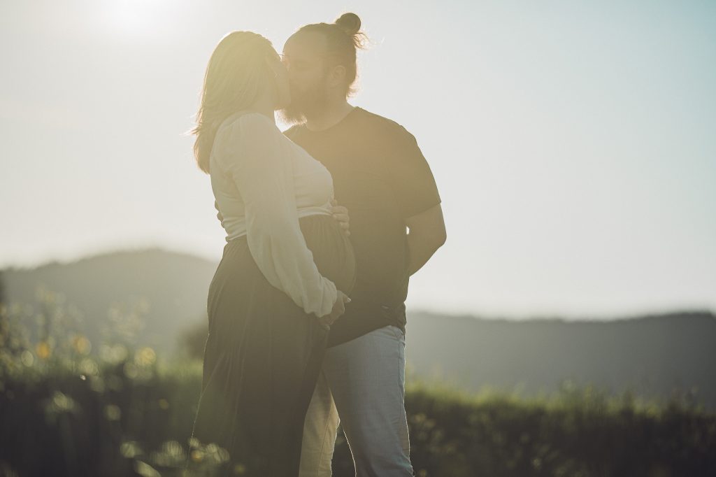 Babybauchshooting im Schwarzwald bei Sonnenuntergang, verliebtes Paar im Gegenlicht, Schwangerschaft, Natur, Zweisamkeit