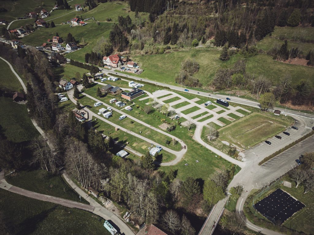 Drohnenbild vom Natur-Camp Tannenfels mit Stellplätzen, Parkflächen und umliegender Schwarzwaldlandschaft