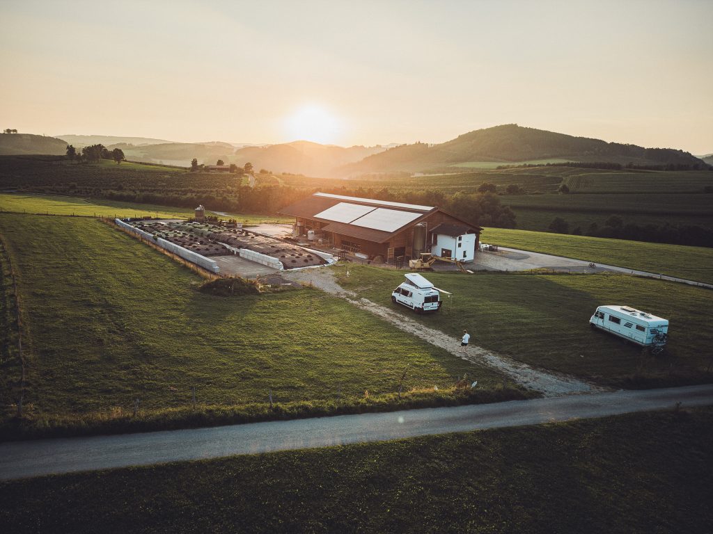 Drohnenaufnahme vom Hof Hinnderkes mit Campern bei Sonnenuntergang