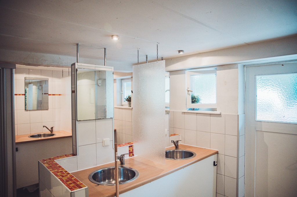 Innenansicht der Sanitäranlagen mit Waschbecken, Spiegeln und Fliesen am Campingplatz Niemetal.