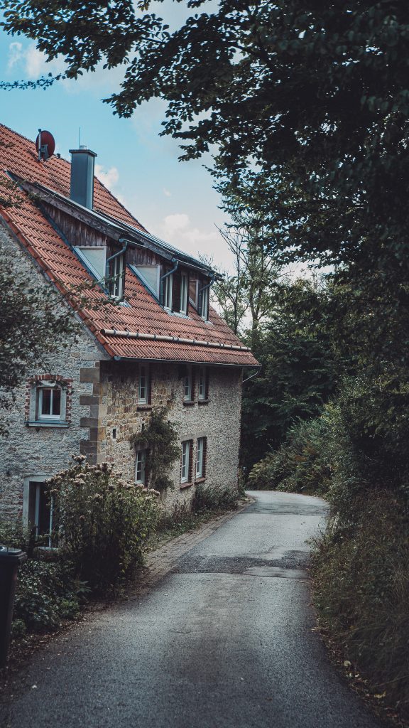 Steinhaus mit rotem Ziegeldach an schmaler Straße in Heiligenkirchen