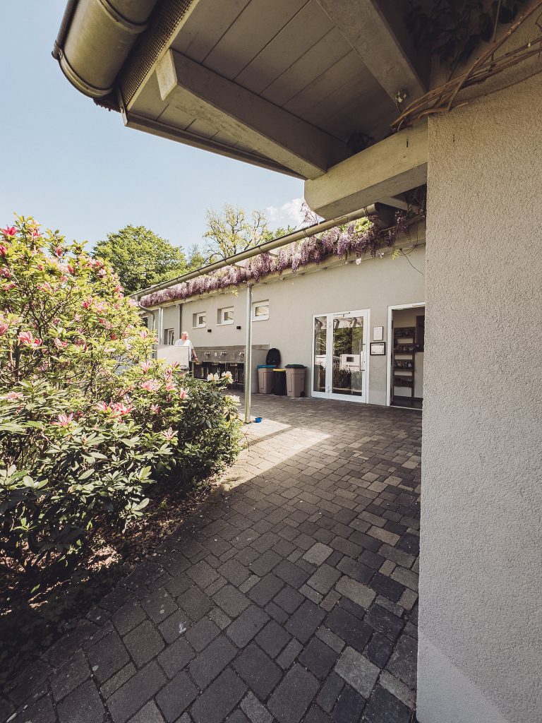 Weg mit Blumen zum Sanitärgebäude des Camping Möslepark Freiburg