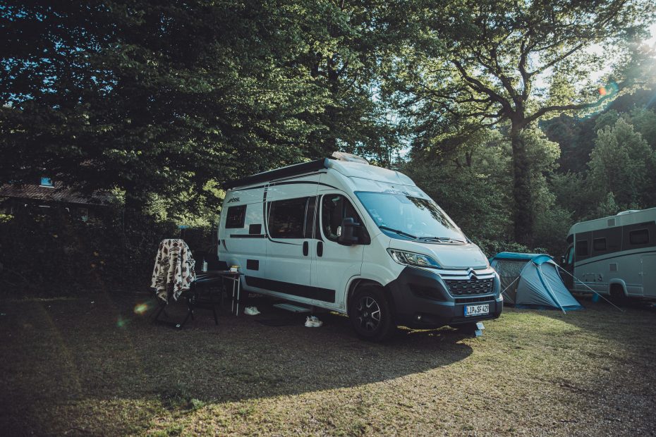 Camper auf grünem Stellplatz unter Bäumen im Camping Möslepark Freiburg