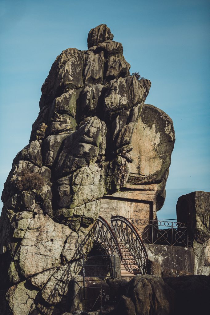 Blick auf die Metallbrücke zwischen den hohen Felsen der Externsteine in Lippe