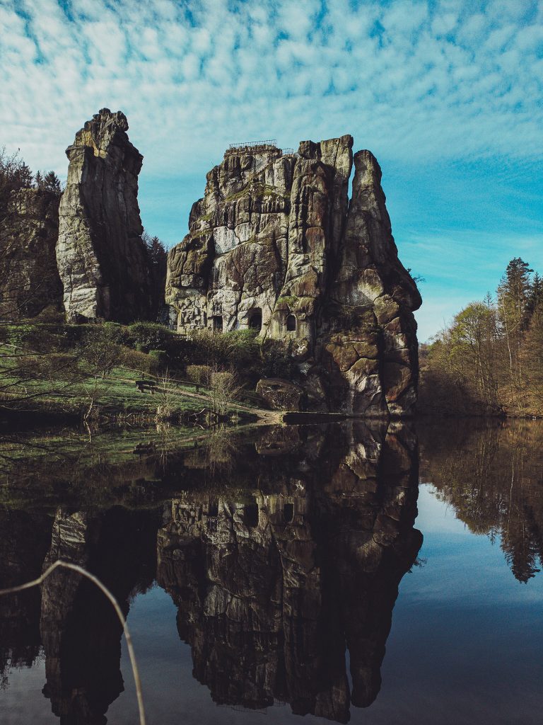 Externsteine mit klarer Spiegelung im See im Teutoburger Wald bei Horn-Bad Meinberg