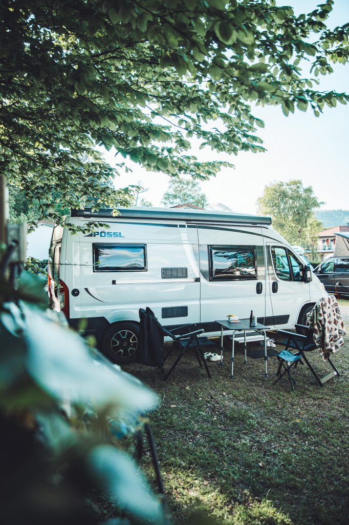 Camper mit Sitzgarnitur und Bäumen auf dem Camping Möslepark in Freiburg