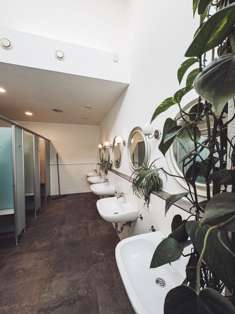 Waschbecken und Pflanzen im modernen Sanitärbereich des Camping Möslepark Freiburg