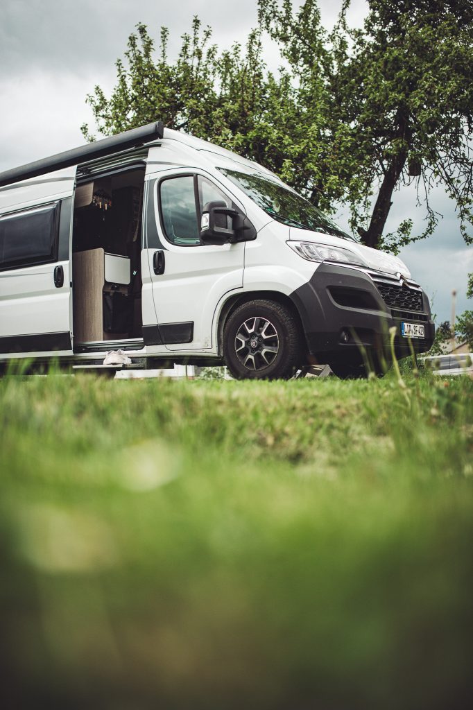 Weißer Camper mit geöffneter Tür auf der Wiese von Kochs Hof in Hessen