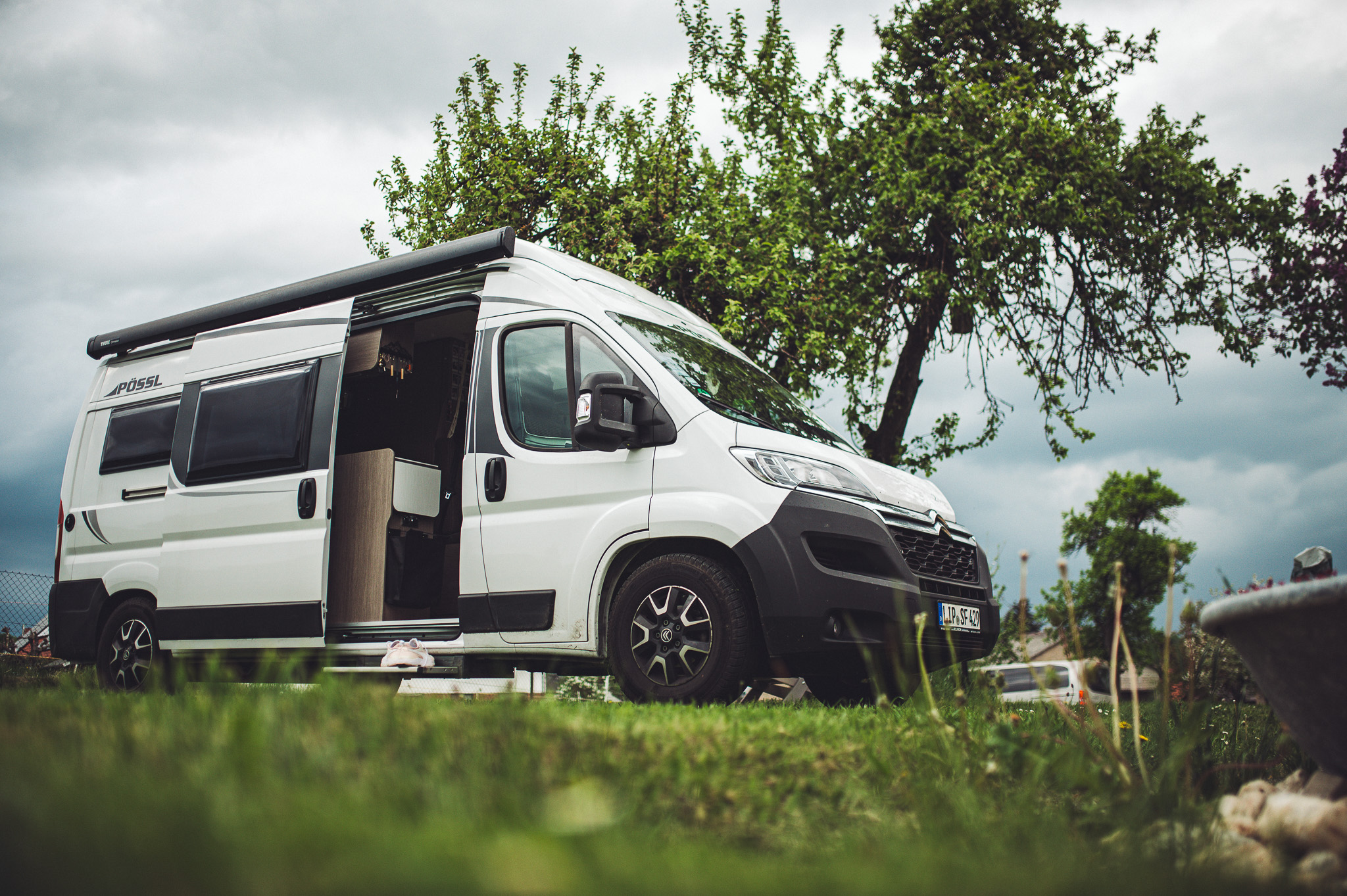 Weißer Camper auf einer Wiese mit Bäumen auf Kochs Hof in Hessen