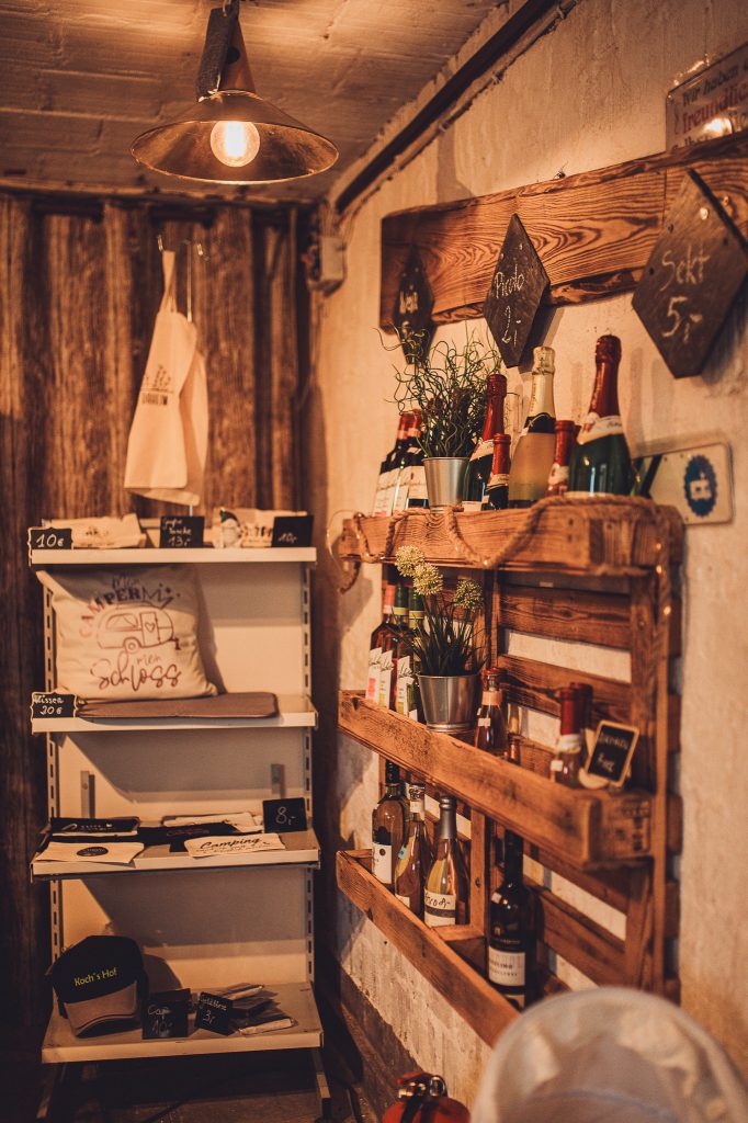 Regale mit Getränken, Dekoartikeln und Campingprodukten im Hofladen von Kochs Hof in Hessen