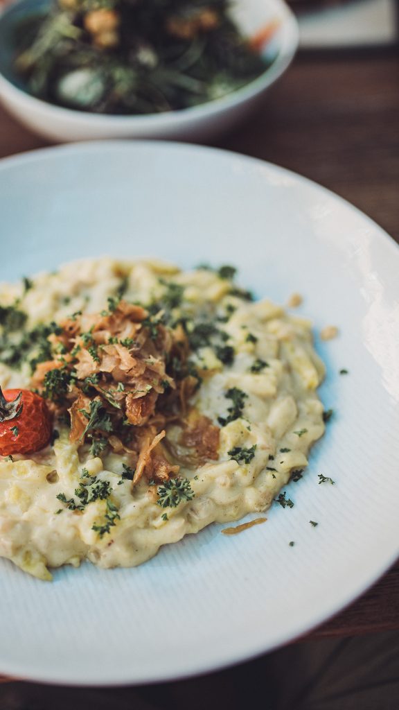 Teller mit cremigen Käsespätzle und Röstzwiebeln im Restaurant