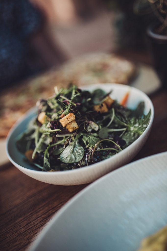 Schüssel mit Wildkräutersalat und Croutons auf dem Restauranttisch