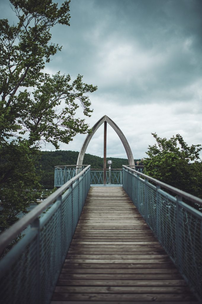 Holzsteg führt zu einer Aussichtsplattform mit Holzbogen am Baumwipfelpfad Kellerwald-Edersee