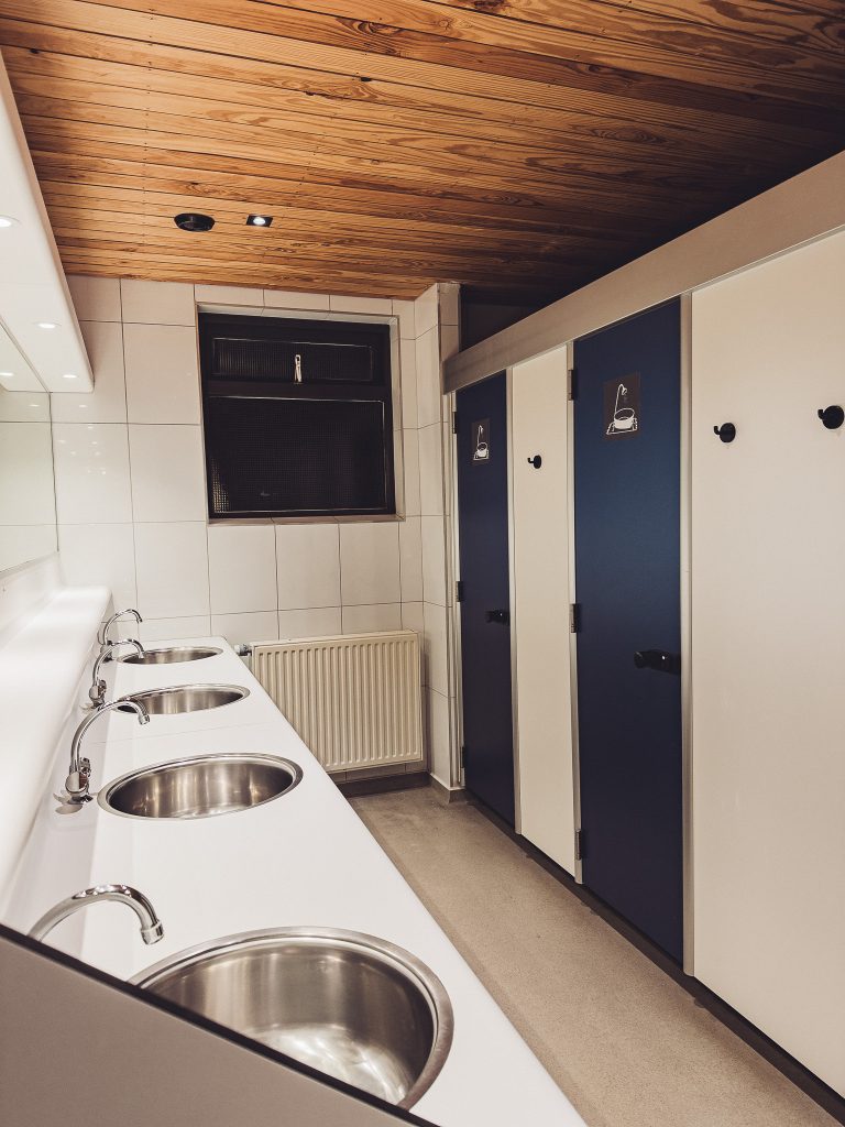 Innenraum des Sanitärhauses im CityKamp Valkenburg mit mehreren Waschbecken und Kabinen