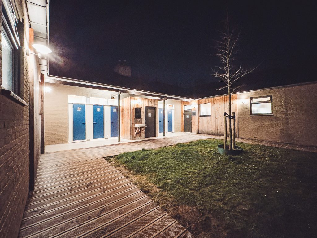 Beleuchteter Innenhof des Sanitärbereichs im CityKamp Valkenburg bei Dunkelheit