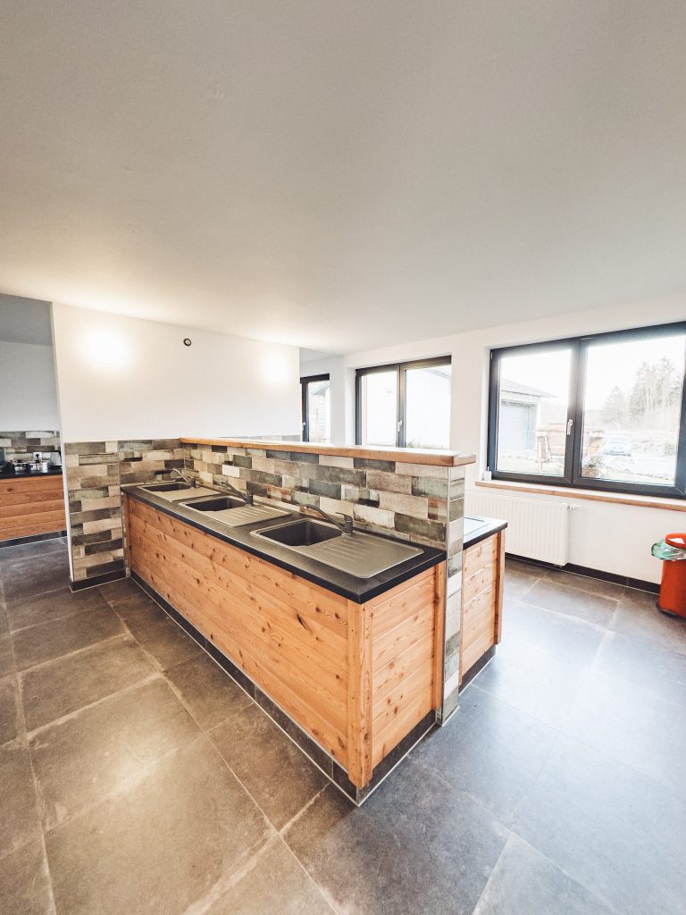 Holzpod-Unterkunft im Harz Camp Goslar mit gebogenem Dach und Holzfassade vor winterlich kahlem Wald