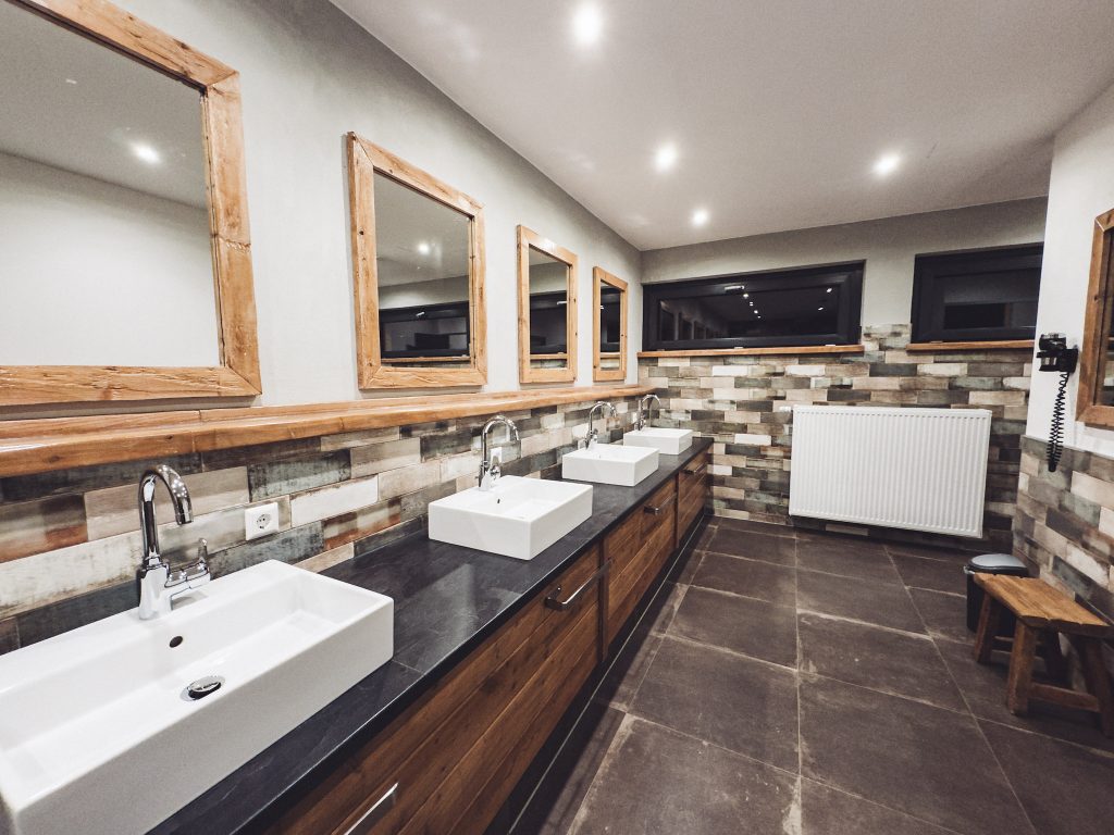 Innenraum der Spül und Kochküche im Harz Camp Goslar mit Edelstahlspülen, Holzverkleidung und großen Fenstern