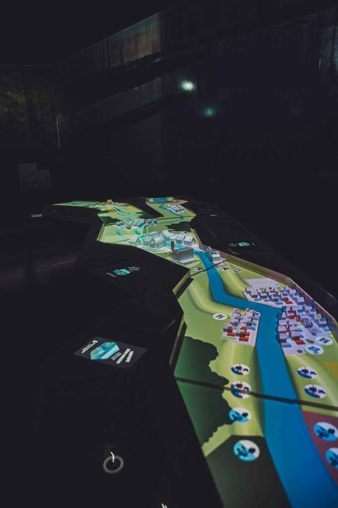 Digitale Landschaftskarte mit Fluss und Siedlungen in dunklem Raum