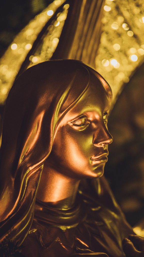 Goldene Madonnenfigur im warm beleuchteten Höhlenbereich in Valkenburg