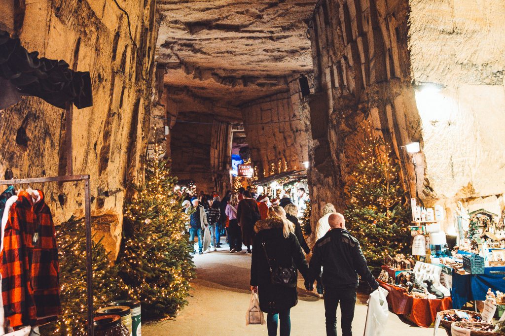 Pasaje de cueva con árboles de Navidad, luces y puestos de mercado en Valkenburg