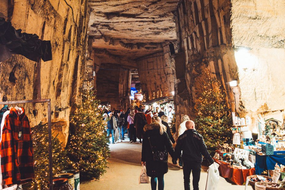 Höhlenpassage mit Weihnachtsbäumen, Lichtern und Marktständen in Valkenburg