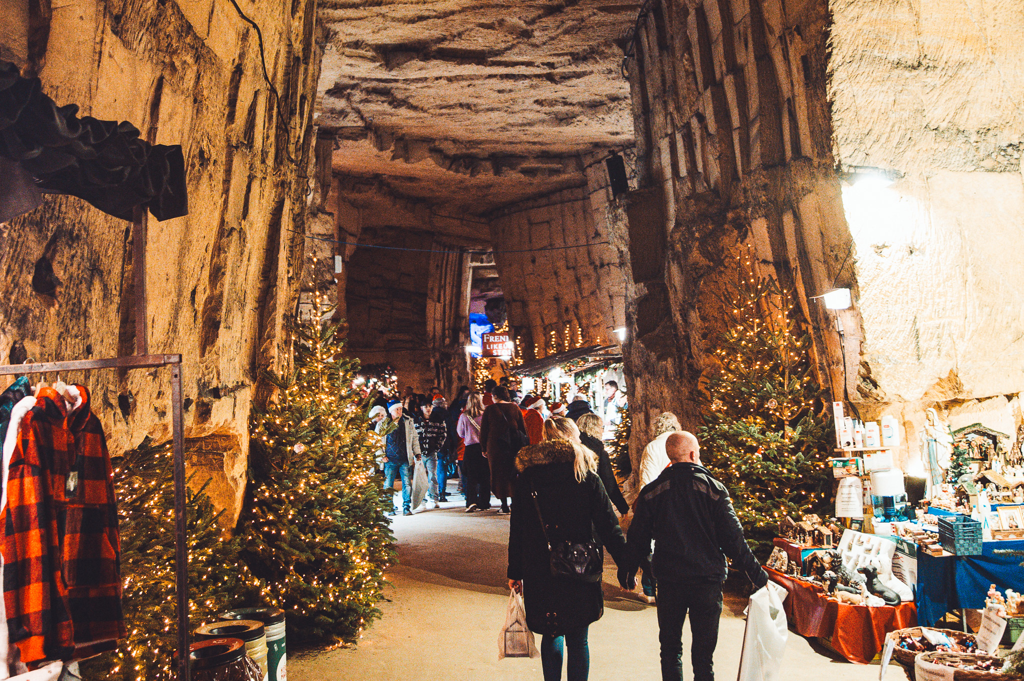 Höhlenpassage mit Weihnachtsbäumen, Lichtern und Marktständen in Valkenburg
