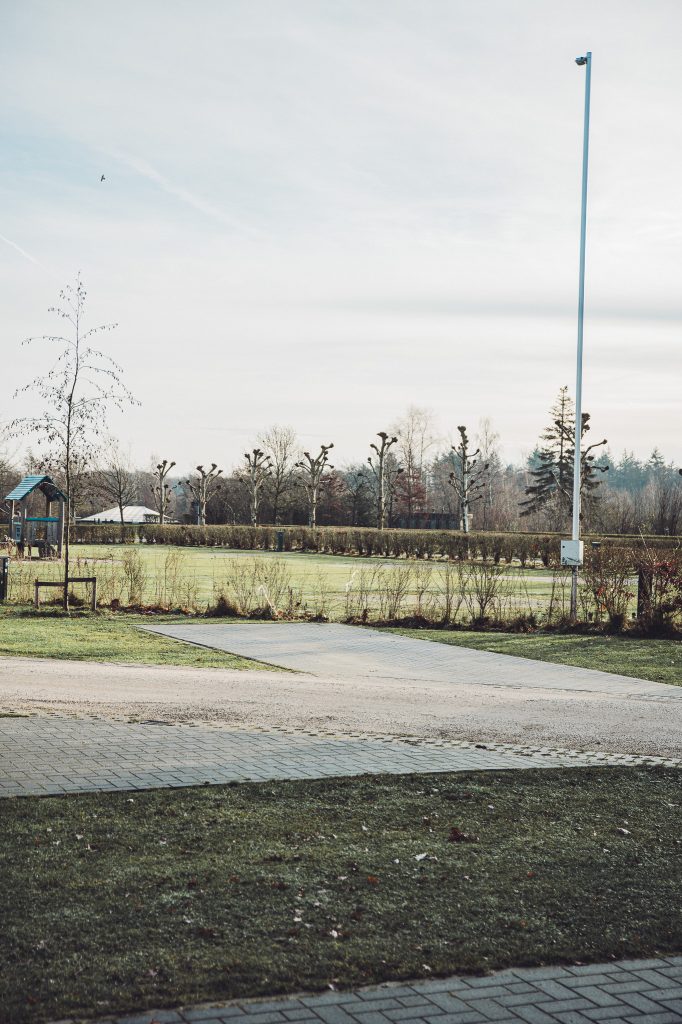 Weitläufiges Gelände mit Rasenflächen und Wegen auf dem Camping Vreehorst im Winter