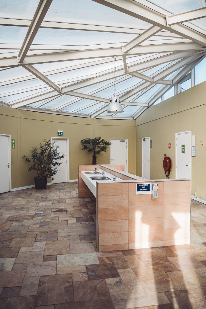 Moderner Sanitärraum mit zentralen Waschbecken und viel Tageslicht auf dem Camping Vreehorst