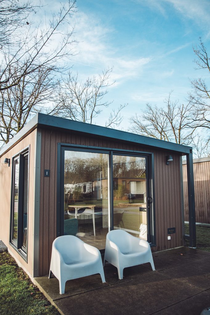 Modernes Tiny House mit Terrasse und Stühlen auf dem Camping Vreehorst