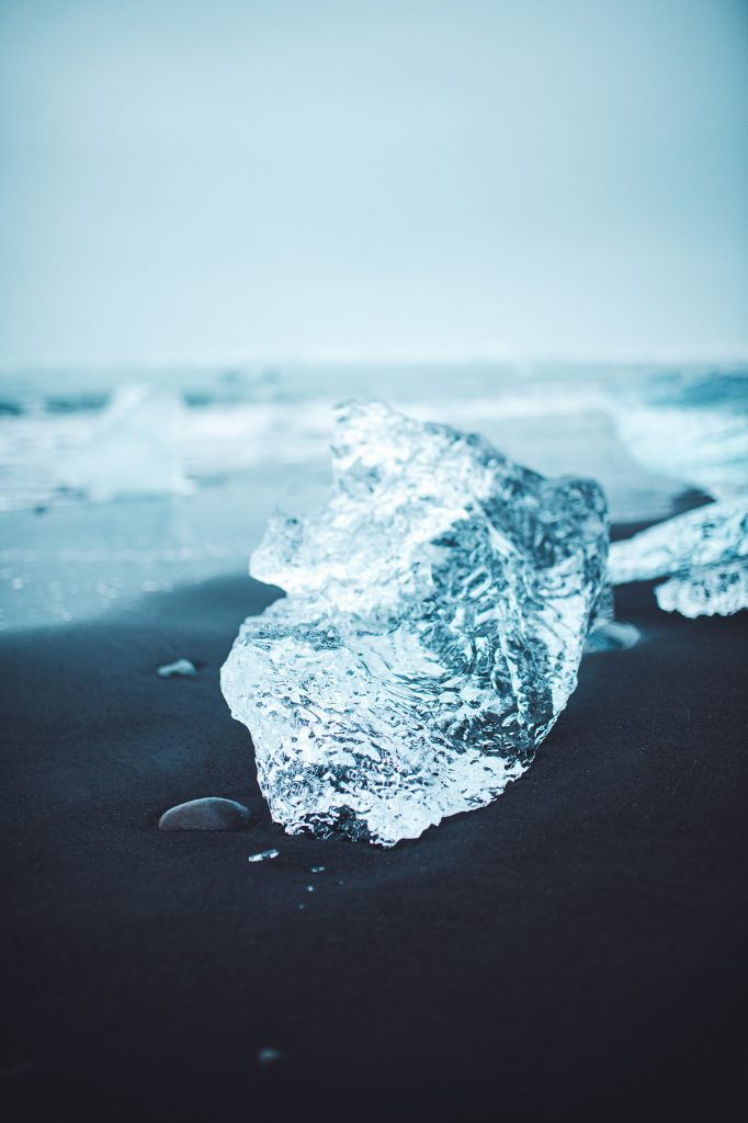 Kleiner Eisbrocken auf schwarzem Sandstrand am Diamond Beach in Island