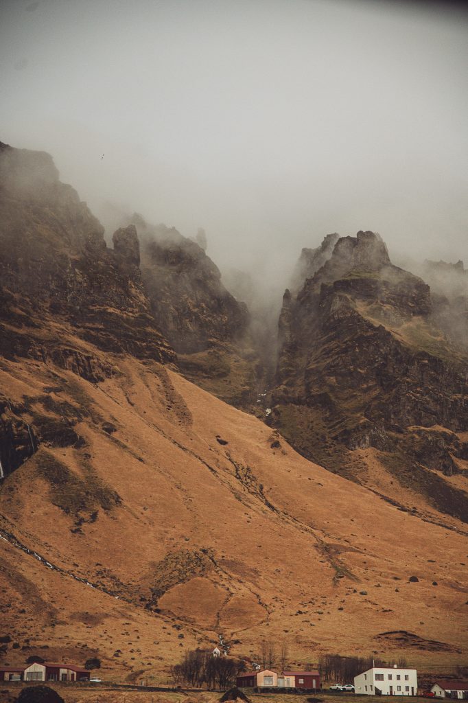 Zackige Felsen in Island mit tief hängendem Nebel und karger Landschaft
