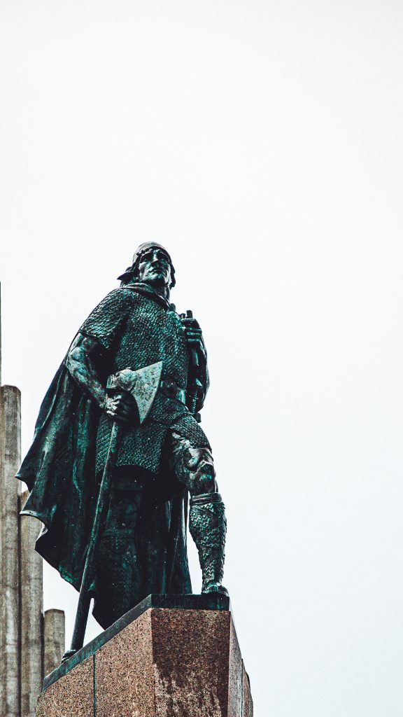 Statue eines Wikingers als Denkmal in Reykjavík vor hellem Himmel