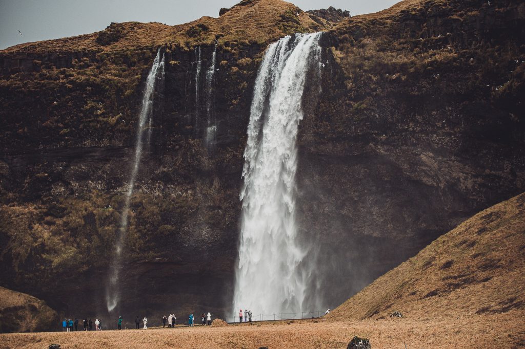 Großer Wasserfall Seljalandsfoss mit Menschen am Fuß des Falls in Island