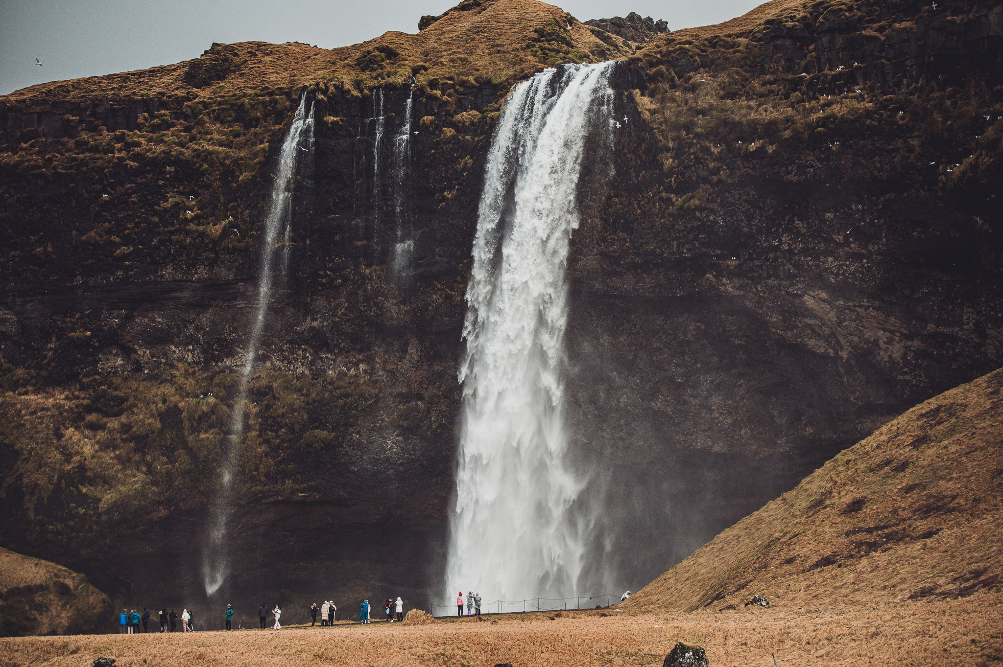 Großer Wasserfall Seljalandsfoss mit Menschen am Fuß des Falls in Island