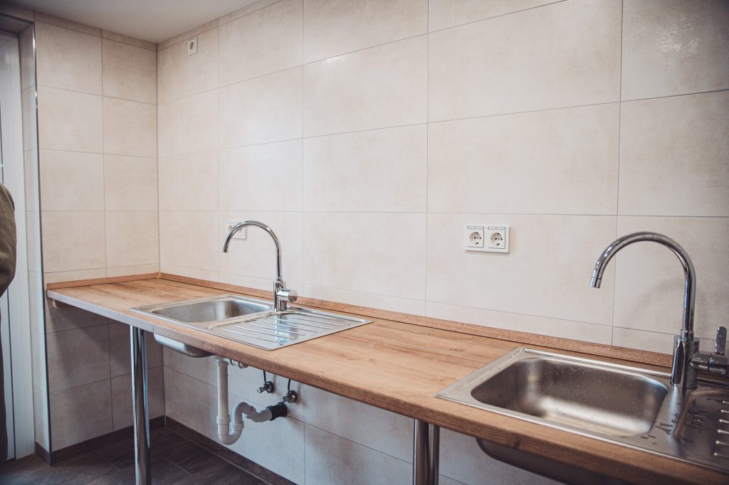 Abwaschbereich mit zwei Edelstahlspülen und Holzarbeitsplatte im Sanitärgebäude am Campingplatz Großes Meer