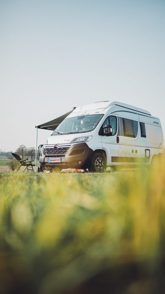 Weißer Camper steht auf einer Wiese am Hof Becker vor der Sandfort mit Blick über den ruhigen Landvergnügen Stellplatz