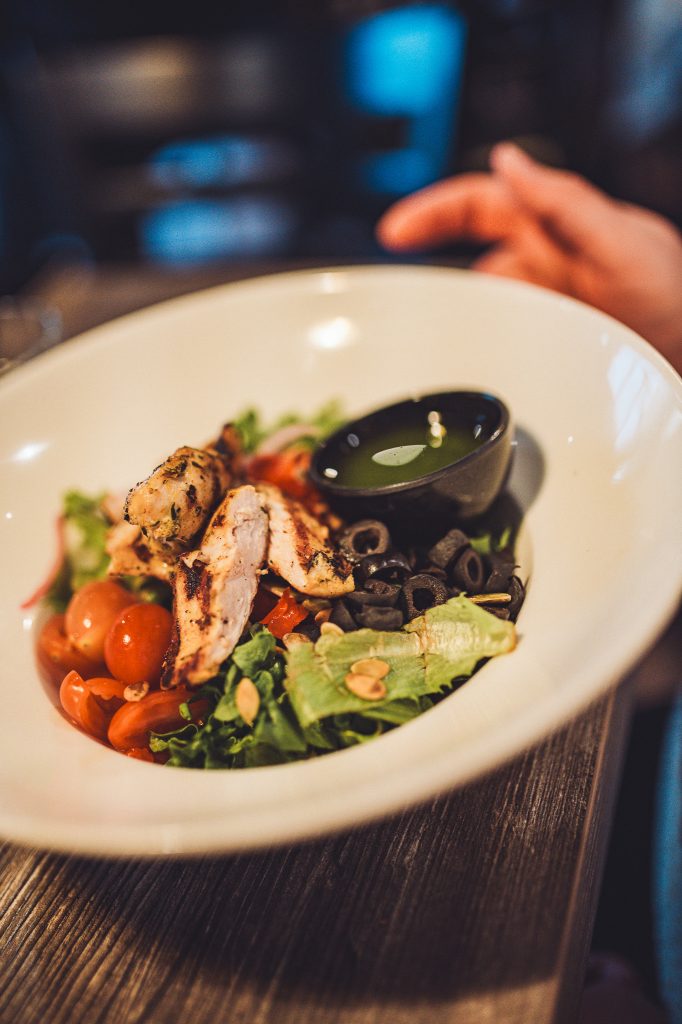 Schale mit Salat, gegrilltem Hähnchen, Tomaten und Oliven im Systrakaffi Restaurant in Südisland