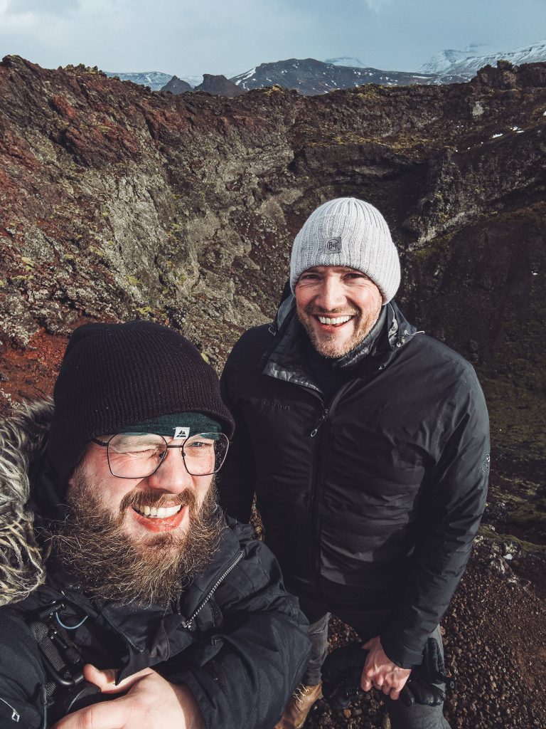 Zwei Wanderer am Kraterrand des Eldborg in Island mit dem Vulkankrater im Hintergrund