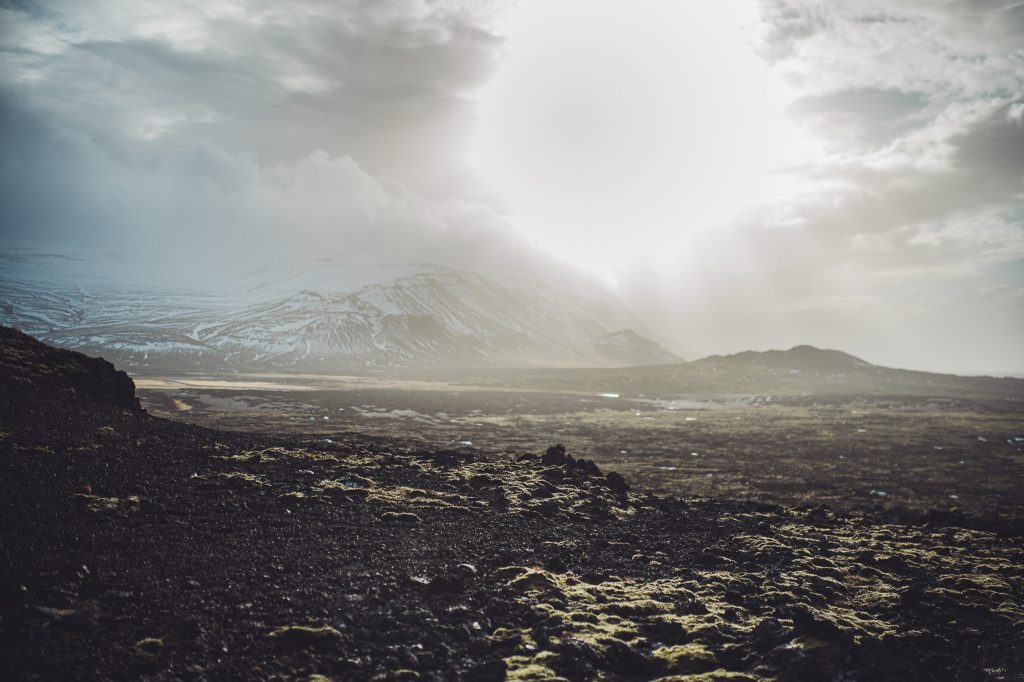 Weites Vulkanfeld am Eldborg in Island mit Gegenlicht und Bergkulisse