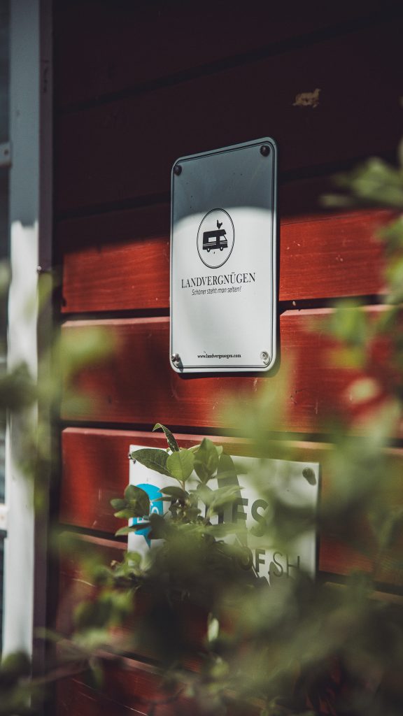 Landvergnügen Schild an der roten Holzfassade vom Hofladen des Biohof Hümme