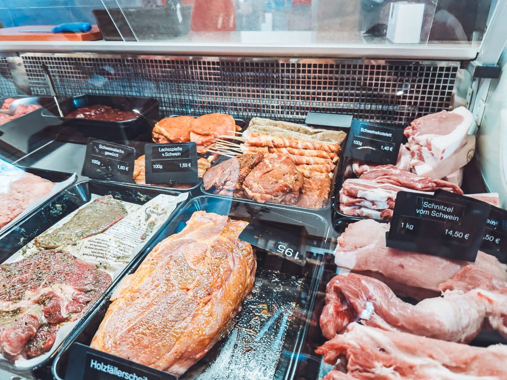 Fleischtheke im Hofladen Lindenhof Broosch mit mariniertem Grillfleisch, Spießen und Schweinefleisch.
