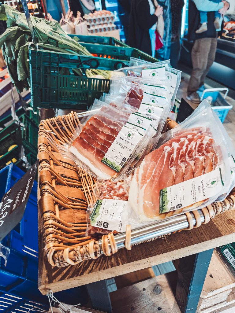 Korb mit verpacktem Schinken und Wurstwaren im Hofladen Lindenhof Broosch.