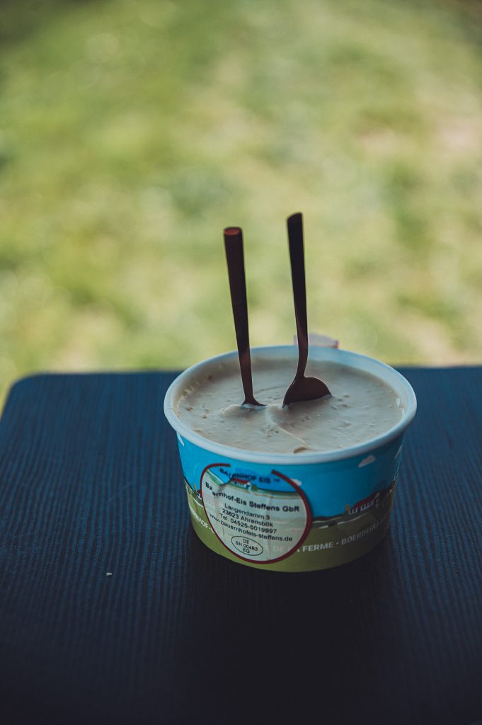 Becher Eis mit zwei Löffeln auf einem Campingtisch beim Lindenhof Broosch nahe Timmendorfer Strand.