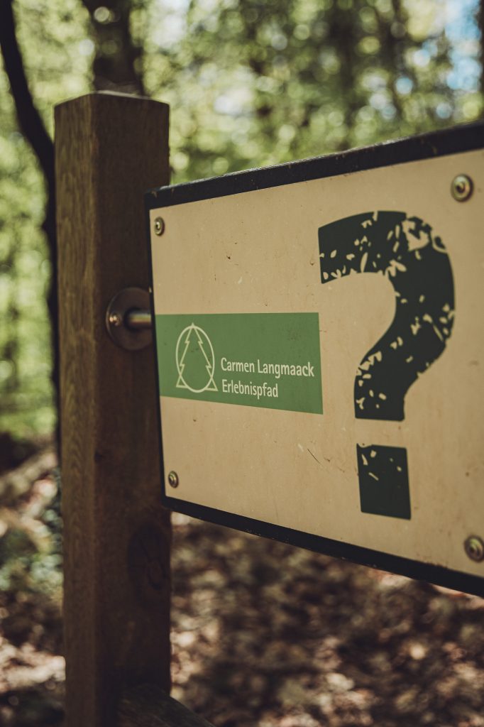 Schild des Carmen Langmaack Erlebnispfads im Wildpark Mölln an einem Holzpfosten