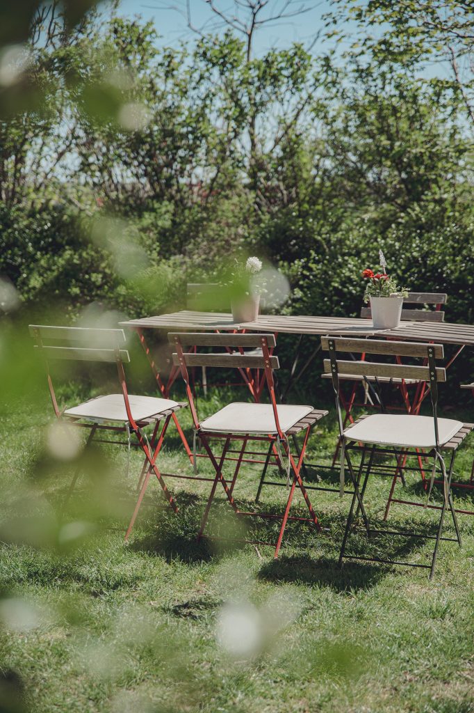 Leere Tische und Stühle im sonnigen Garten vom Hofcafé bei Blümels Hof nahe Buxtehude